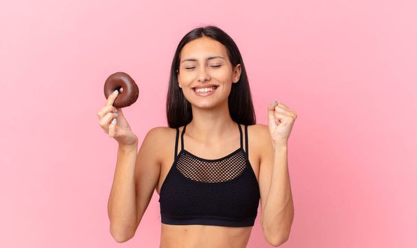 pretty fitness woman with a donut and a breakfast bowl - Zdjęcie, obraz