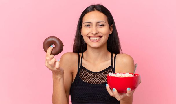 pretty fitness woman with a donut and a breakfast bowl - Zdjęcie, obraz