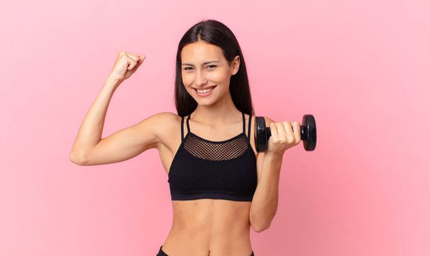 hispanic pretty woman with a dumbbell. fitness concept - Фото, зображення