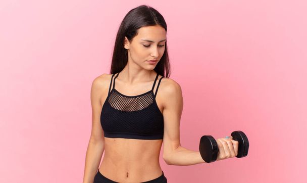 hispanic pretty woman with a dumbbell. fitness concept - Foto, Imagem