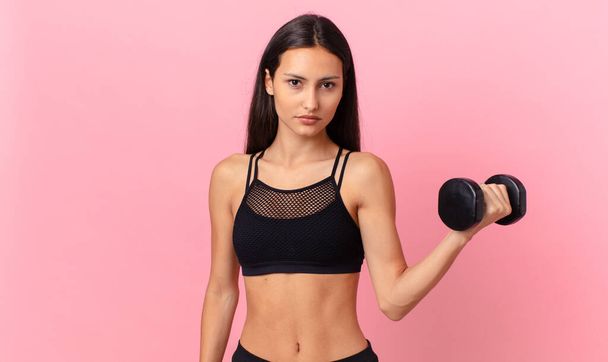 hispanic pretty woman with a dumbbell. fitness concept - Photo, image