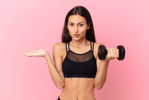 hispanic pretty woman with a dumbbell. fitness concept - 写真・画像