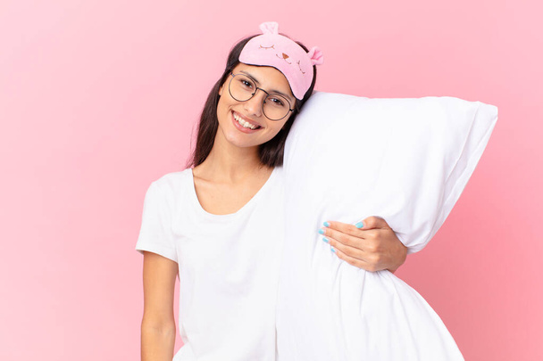 hispanic pretty woman wearing pajamas and holding a pillow - Foto, afbeelding