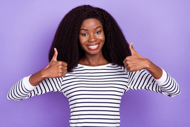 Photo of funny young lady show thumb up wear striped sweater isolated on violet color background - Photo, Image