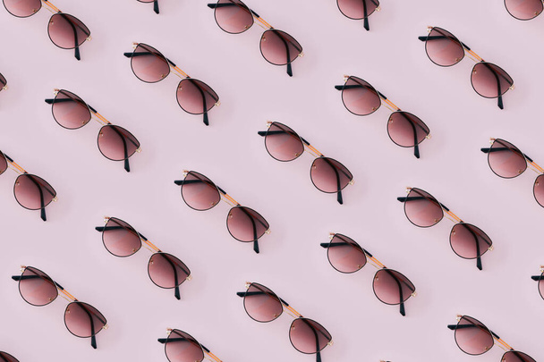Patrón de verano hecho con gafas de sol de mujer sobre fondo rosado. - Foto, Imagen