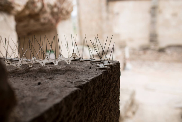 Tarihi binanın köşesine itici metal çiviler yerleştirilmiş. Mimari Miras İçin Kuş Kontrol Konsepti - Fotoğraf, Görsel