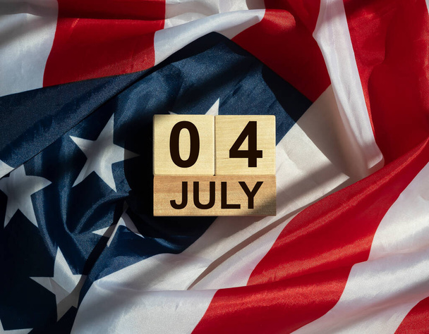 7月4日アメリカ国旗の上に木製のカレンダーの碑文。独立記念日 - 写真・画像