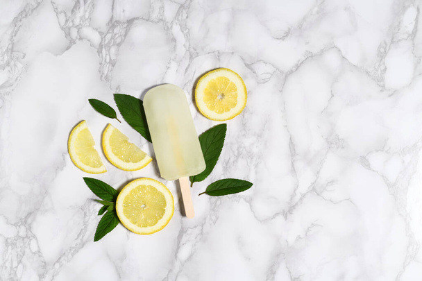 Lemon popsicle on marble table - Foto, Imagen