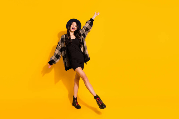 Photo of inspired lady dance enjoy wear hat checkered coat mini dress footwear isolated yellow color background - Φωτογραφία, εικόνα