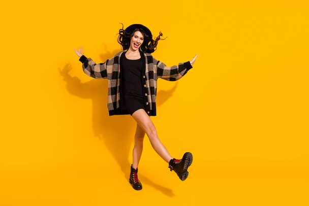 Photo of active lady dance go wear headwear checkered jacket short dress shoes isolated yellow color background - Fotoğraf, Görsel
