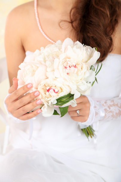 Bride holding wedding bouquet of white peonies, close-up, on light background - Fotoğraf, Görsel