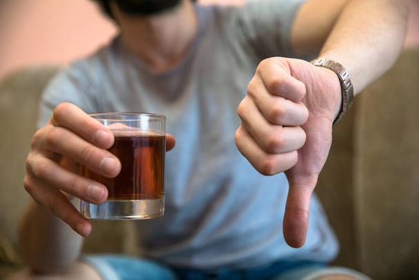 man hand glass of alcohol and bad sig - Φωτογραφία, εικόνα