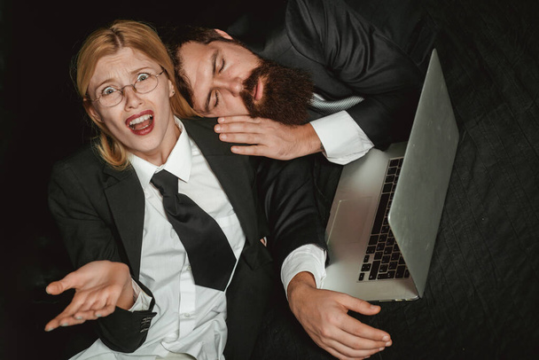 Tired, overworked business couple. Tired businessman sleeping in dark office. Man sleeping at working place. Young business woman overworked at office. Overwork, office syndrome, business problem. - Foto, Imagen