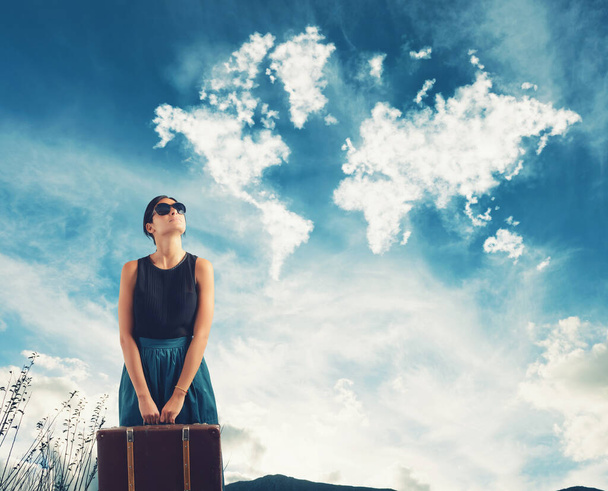 Девушка с чемоданом в руке представляет себе путешествие по миру - Фото, изображение