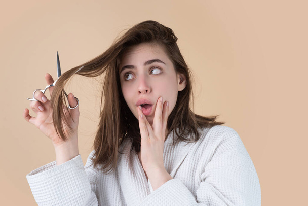 Sad woman having her hair cut with scissors. Beautiful woman in panic because of hair loss. Woman with hair loss problem. - Foto, afbeelding