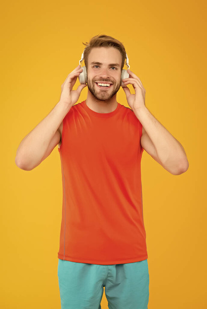 Get your best Solution. sport and music. quality of sound. innovative wireless device. workout. sportsman guy with ear stereo headphones. male fitness fashion. man in headset listen song for training - Fotó, kép