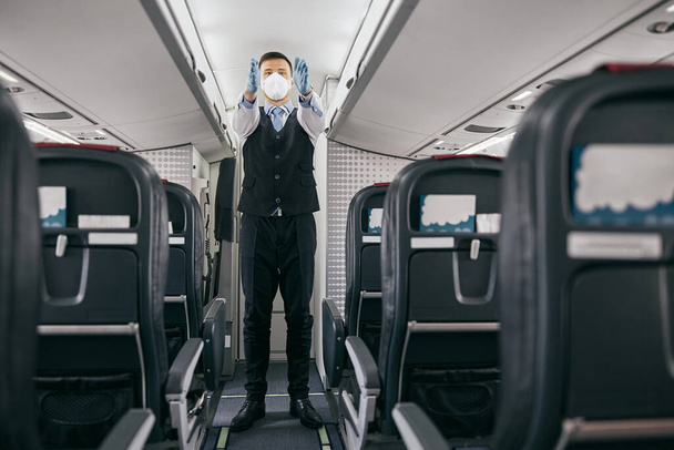 Vliegtuigexploitant geeft veiligheidsinstructies aan mensen - Foto, afbeelding