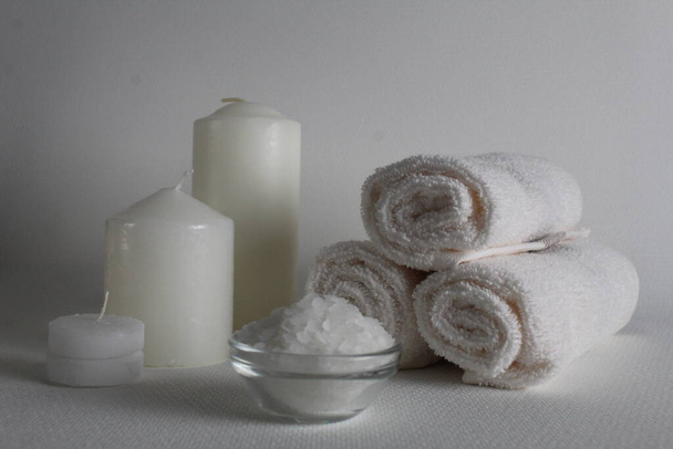 Spa salon towels slide candle salt oil on a white background with room for insertion. A copyspace. Home treatments. - Photo, Image