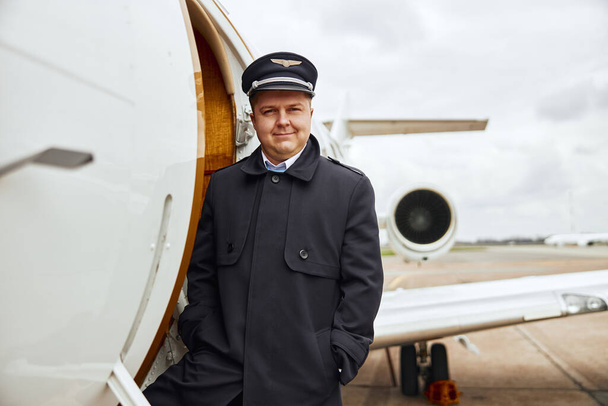 Pilot stojící u vchodu do letadla - Fotografie, Obrázek