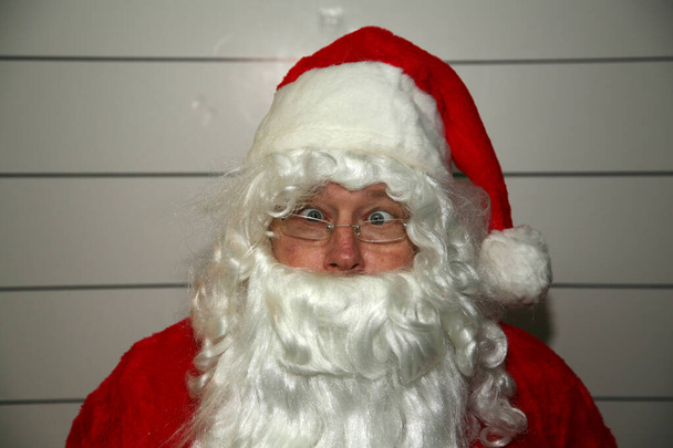 Santa Claus Mug Shot Різдво Санта Клауса. Santa Claus Mug Shot Санту заарештовують, а його фотографію знімає Муг-Скотт. Санта Клаус заарештований на Різдво. У Санта Клауса Муг стріляють. Санта наляканий..  - Фото, зображення