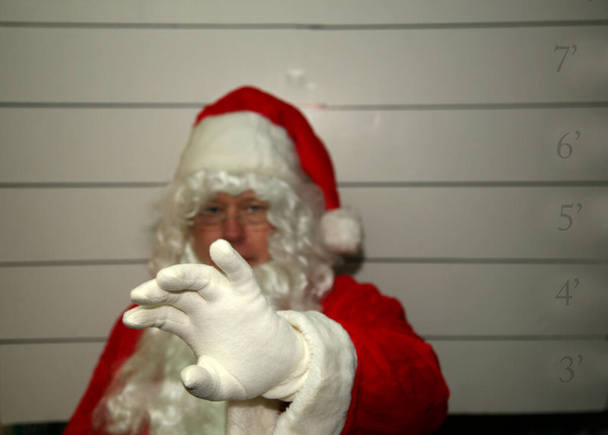 Santa Claus Mug Shot Різдво Санта Клауса. Santa Claus Mug Shot Санту заарештовують, а його фотографію знімає Муг-Скотт. Санта Клаус заарештований на Різдво. У Санта Клауса Муг стріляють. Санта наляканий..  - Фото, зображення