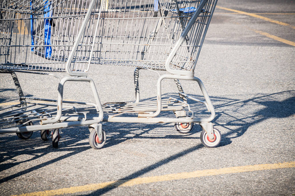 Un primer plano de un carrito de compras en el estacionamiento de una tienda de comestibles. - Foto, imagen