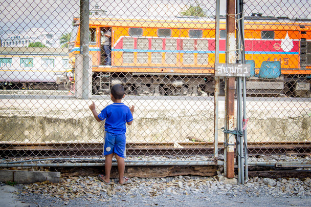 Asyalı çocuk tren istasyonunda tren arıyor. - Fotoğraf, Görsel