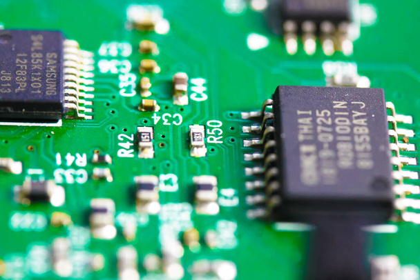 A green electronic circuit board flatly. Top view of pcb board circuit close-up. Radio amateur designs for electrically and mechanically connecting various electronic components. Technology background - Photo, Image