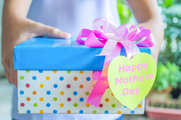 Рука дитини дарує подарунок на День матері. - Фото, зображення