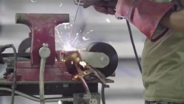 Egy férfi kovács hegesztő vas forrasztó egy bilincs egy hajó gyártó raktárban - Felvétel, videó