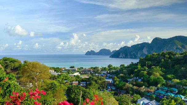 panoramatický výhled z vyvýšeného úhlu pohledu na ostrov Phi Phi, krásná turistická místa jako ráj s výhledem na dům Budovy od hotelů a letovisek až k pobřeží a modré obloze. - Fotografie, Obrázek