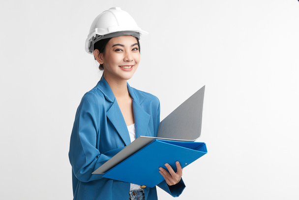 красивая азиатская женщина инженер и защитный шлем на белом фоне, концепция строительства, инженер, промышленность. - Фото, изображение
