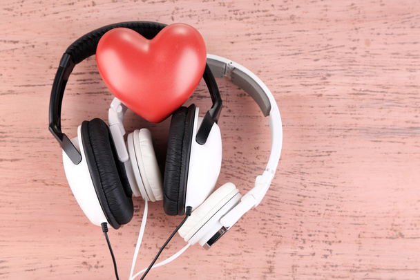 Headphones and heart on color wooden background - Photo, Image