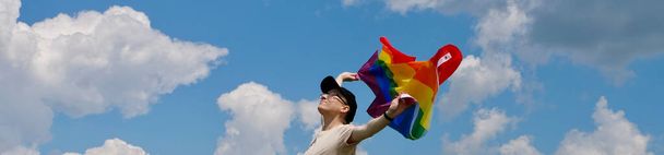 Person holding LGBT flag on sky background - Zdjęcie, obraz
