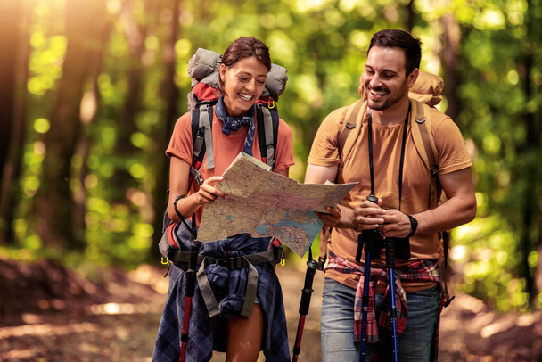 Couple exploring a new destination on map in the forest. - Photo, Image