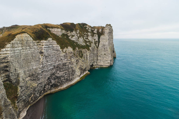 The famous Etretat Aval cliff and natural arch landmark by the ocean in Normandy, France - 写真・画像