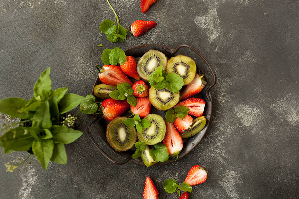 bright and fresh strawberries and kiwi on a dark background - Photo, image