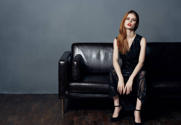 beautiful woman in black dress sitting on sofa posing interior glamor - Fotoğraf, Görsel