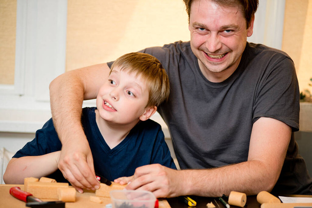 Building relations. Father-child interactions. Activities at home. Boy and father Playing with DIY Toys Carpentry Construction Engineering Tool Workshop Kit.  - Foto, immagini