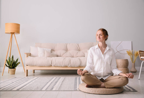 Woman meditating on wicker mat at home. Space for text - Photo, Image