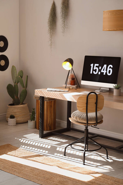 Room interior with comfortable workplace. Modern computer on wooden desk - 写真・画像