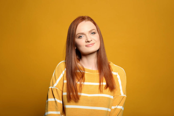 Őszinte portré boldog fiatal nő bájos mosollyal és gyönyörű vörös haj sárga háttér - Fotó, kép