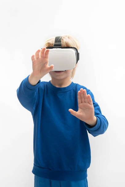 Child in VR glasses plays virtual reality game. Isolated on white background. Vertical frame. - Φωτογραφία, εικόνα