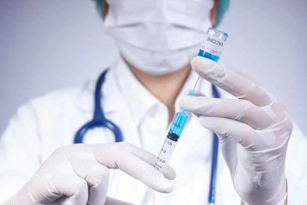 Лікар тримає пляшку вакцини проти вірусу корона, концепція лікування коронавірусу
 - Фото, зображення