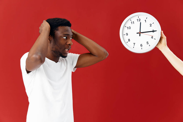 man in surprise looks at his watch in a white t-shirt - Photo, Image