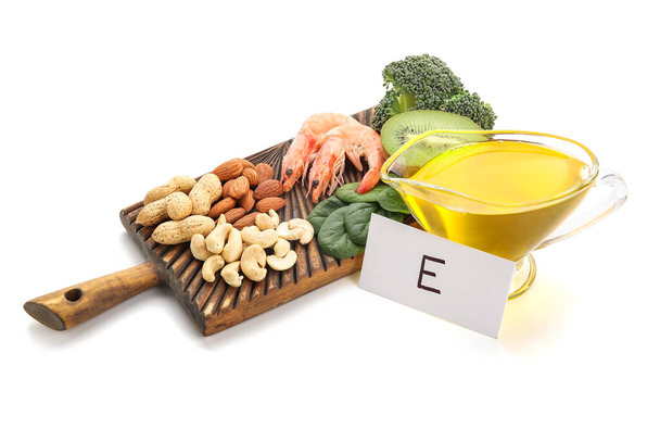 Tablero con productos saludables ricos en vitamina E sobre fondo blanco - Foto, imagen