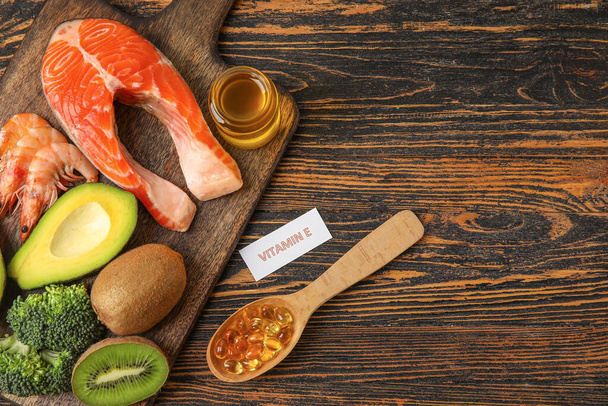 Tafel mit gesunden Produkten reich an Vitamin E und Fischöl-Kapseln auf Holzgrund - Foto, Bild