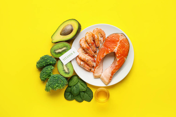 Placa con productos saludables ricos en vitamina E sobre fondo de color - Foto, imagen