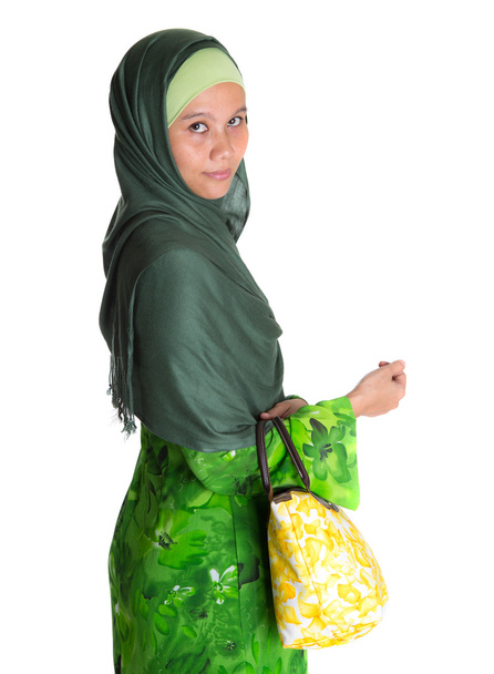 Mujer musulmana en vestido verde con bolso amarillo
 - Foto, Imagen