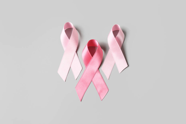 グレーの背景にピンクのリボン。乳がんの概念 - 写真・画像